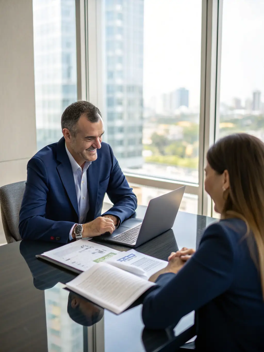 A young Indian professional is consulting a financial advisor in a modern office, discussing various investment and savings options for their future.