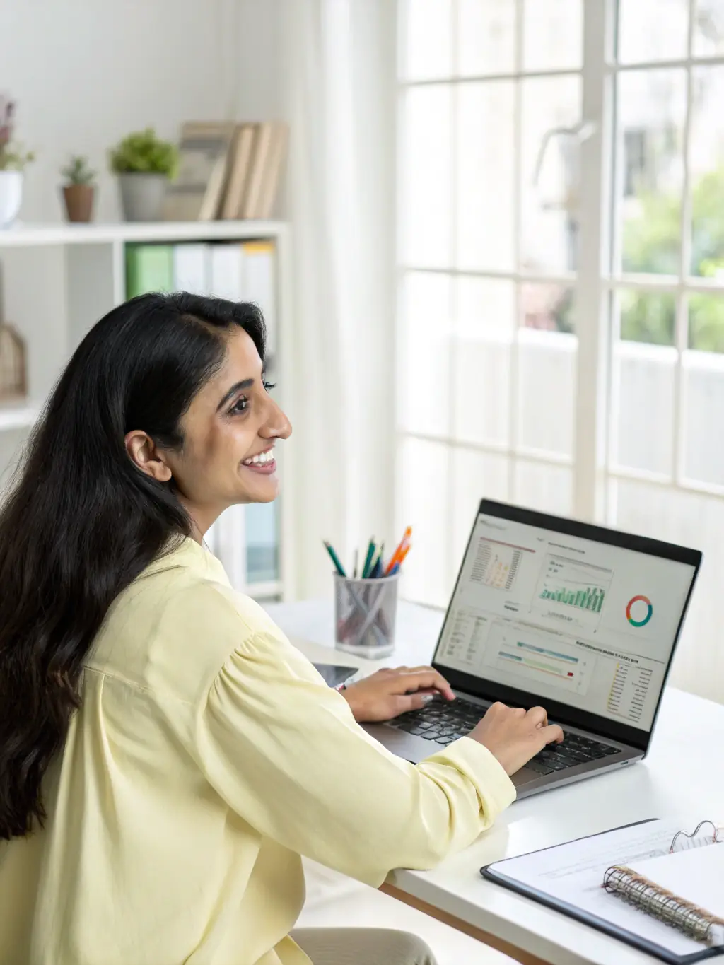 A modern Indian woman is confidently managing her finances on a laptop, researching different savings schemes and investment options.